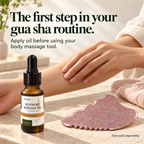 DemiBu Mugwort Massage Oil beside a rose-coloured body gua sha tool while a hand massages a forearm; tool sold separately.
