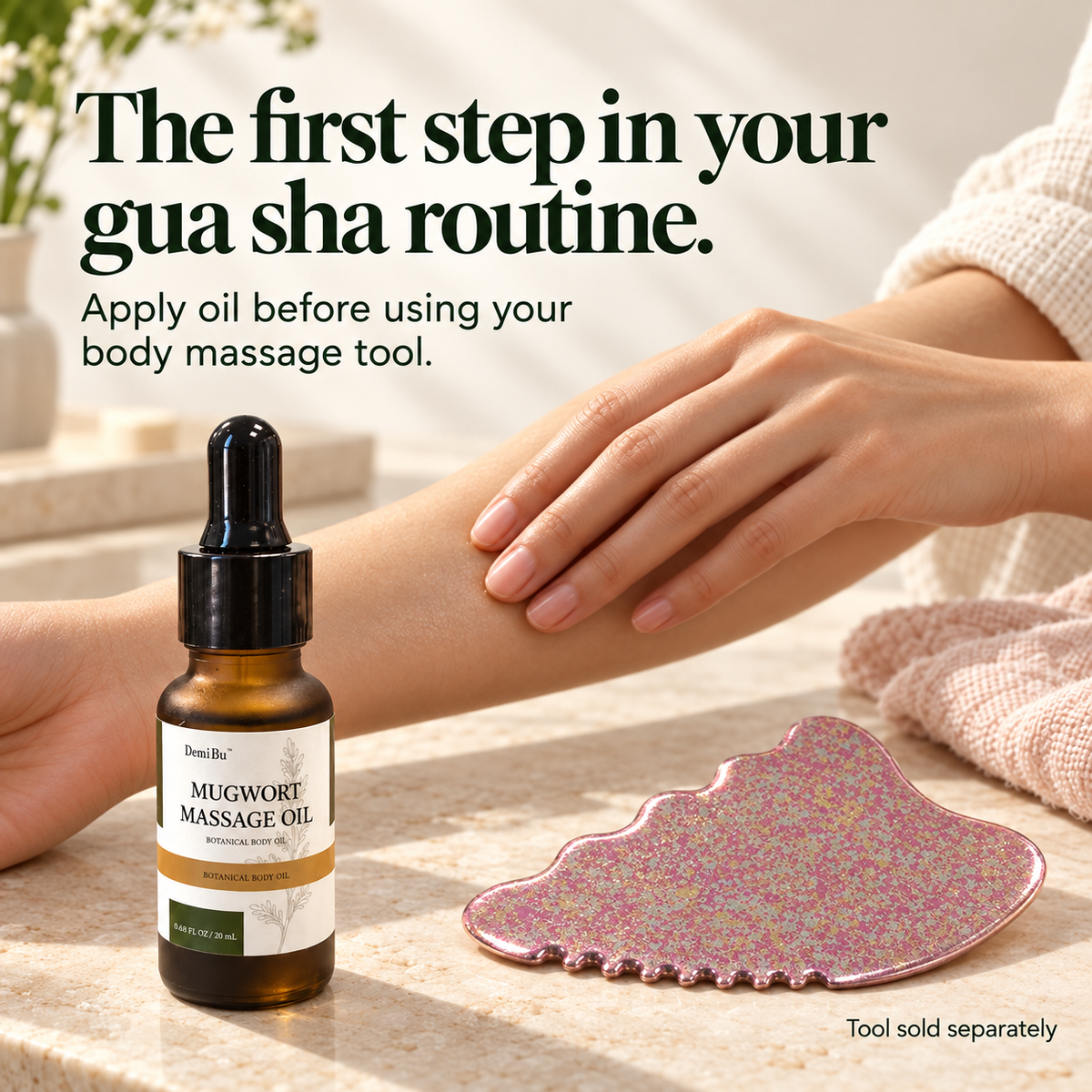 DemiBu Mugwort Massage Oil beside a rose-coloured body gua sha tool while a hand massages a forearm; tool sold separately.