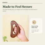 Hand holding a carbonized beech wood body board through the open grip